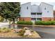 Charming building exterior featuring balconies, brick accents, lush landscaping, and assigned unit entrances at 7665 E Eastman Ave # 202A, Denver, CO 80231