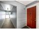 Interior building hallway leading to unit 202 with a bright red door and well-lit corridor at 7665 E Eastman Ave # 202A, Denver, CO 80231