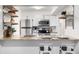 Open kitchen with stainless steel appliances, granite countertops, and floating shelves at 7665 E Eastman Ave # 202A, Denver, CO 80231