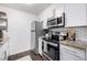 Efficient kitchen featuring stainless steel appliances, white cabinets, and granite counters at 7665 E Eastman Ave # 202A, Denver, CO 80231