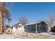 Home exterior showcasing a detached garage and snowy yard at 3756 Decatur St, Denver, CO 80211