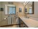 Bathroom with dark wood vanity, marble countertop, framed mirror, and blind-covered window at 3163 Windstream Ln, Elizabeth, CO 80107