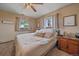 Cozy bedroom with neutral tones, a ceiling fan, and ample natural light from two windows at 3163 Windstream Ln, Elizabeth, CO 80107