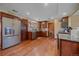 Well-lit kitchen with granite countertops, wood floors, and stainless steel refrigerator at 3163 Windstream Ln, Elizabeth, CO 80107