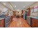 Open-concept kitchen and dining area featuring wood cabinets, stainless steel appliances, and hardwood floors at 3163 Windstream Ln, Elizabeth, CO 80107
