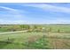Expansive green land with a wooden fence and blue skies providing a serene and open view at 3163 Windstream Ln, Elizabeth, CO 80107