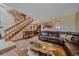 Spacious living area featuring a leather couch, wood flooring, and a staircase with a unique decorative element at 3163 Windstream Ln, Elizabeth, CO 80107