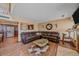 Comfortable living room with a large leather sectional, warm wood floors, and seamless flow to the kitchen at 3163 Windstream Ln, Elizabeth, CO 80107