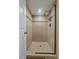 Tiled shower featuring glass enclosure, rainfall shower head, and built-in shelving for a spa-like experience at 3163 Windstream Ln, Elizabeth, CO 80107