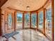 Bright sun room featuring hardwood floors, wood ceiling and multiple windows at 23231 Maricopa Rd, Indian Hills, CO 80454