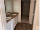 Bathroom featuring double sinks, cabinets, and a walk-in closet at 317 Whimsical Ave, Brighton, CO 80603