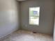 Empty bedroom shows a window overlooking the front yard of the home and awaiting your personal touches at 317 Whimsical Ave, Brighton, CO 80603