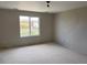 A bedroom with a window looking out onto a street with other homes at 317 Whimsical Ave, Brighton, CO 80603
