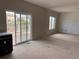 Open concept living room with sliding glass door access to deck and decorative wall awaiting your design touches at 317 Whimsical Ave, Brighton, CO 80603