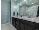 Bright bathroom boasts a double vanity with black cabinets, white countertops, and a glass-enclosed shower at 10595 Boston St, Commerce City, CO 80640