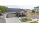 Attractive home with a neat yard, covered porch, and a two-car garage with stone accents at 10595 Boston St, Commerce City, CO 80640