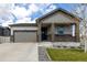 Charming home featuring a covered front porch with stone accents and an attached two-car garage at 10595 Boston St, Commerce City, CO 80640