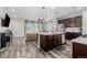 Open-concept living room and kitchen featuring modern lighting, hardwood flooring, and an entertainment area at 10595 Boston St, Commerce City, CO 80640