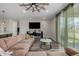 Living room featuring a large sectional sofa, a ceiling fan, a TV, and glass doors leading to an outdoor area at 10595 Boston St, Commerce City, CO 80640