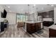 Open-concept living room and kitchen featuring modern lighting, hardwood flooring, and an entertainment area at 10595 Boston St, Commerce City, CO 80640