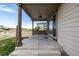 Covered patio with columns, ceiling lights, and a view of a grassy common area at 10595 Boston St, Commerce City, CO 80640