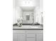 Bathroom featuring double sinks, quartz countertop, and a glass enclosed shower at 2862 S Galapago Ct, Englewood, CO 80110