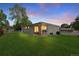 Lovely backyard featuring a well-manicured lawn, covered patio, and grilling area at dusk at 12017 W 58Th Pl, Arvada, CO 80004