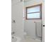 Bathroom featuring a tub and shower combination with white tile and a window for natural light at 12017 W 58Th Pl, Arvada, CO 80004