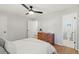 Bright bedroom with hardwood floors, a ceiling fan, and a view into the bathroom at 12017 W 58Th Pl, Arvada, CO 80004