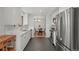 Bright kitchen featuring white cabinetry, stainless steel appliances, and an open layout leading to the dining area at 12017 W 58Th Pl, Arvada, CO 80004