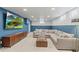 Cozy living room with a large sectional sofa, TV, and blue accent wall at 12017 W 58Th Pl, Arvada, CO 80004