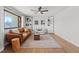 Bright living room featuring a leather couch, a ceiling fan, and built-in shelves at 12017 W 58Th Pl, Arvada, CO 80004