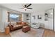 Bright living room featuring a leather couch, a ceiling fan, and built-in shelves at 12017 W 58Th Pl, Arvada, CO 80004