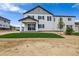 Charming two-story home with gray siding, covered porch, young tree, and landscaped yard at 6636 N Nepal St, Aurora, CO 80019