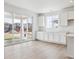 Open-concept living room with bright windows, sliding glass doors, wood-look flooring, and lots of natural light at 6636 N Nepal St, Aurora, CO 80019