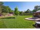Spacious backyard featuring green lawn, playset, and mature trees at 11513 Greenbriar Ln, Parker, CO 80138