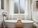 Elegant bathroom featuring a soaking tub, decorative shell art and a window at 11513 Greenbriar Ln, Parker, CO 80138