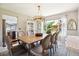 Bright dining room featuring a wood table with seating for six and unique antler chandelier, providing a view of the backyard play area at 11513 Greenbriar Ln, Parker, CO 80138
