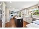 Modern kitchen with hardwood floors, island, white cabinets, stainless steel appliances, and a view of the spacious living room at 11513 Greenbriar Ln, Parker, CO 80138
