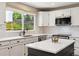 Bright kitchen featuring white cabinets, granite countertops, stainless steel appliances, and a view to a private, fenced backyard at 11513 Greenbriar Ln, Parker, CO 80138