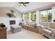 Bright living room with vaulted ceilings, a white brick fireplace, large windows, and a neutral color palette at 11513 Greenbriar Ln, Parker, CO 80138