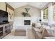 Cozy living room with a white brick fireplace, comfortable seating, and large windows providing natural light at 11513 Greenbriar Ln, Parker, CO 80138
