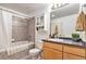 Functional bathroom featuring tiled shower and tub, vanity, medicine cabinet and natural light at 275 S Harrison St # 210, Denver, CO 80209