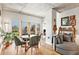 Cozy living area with a round dining table, comfortable seating, natural light, and exposed concrete ceiling at 275 S Harrison St # 210, Denver, CO 80209