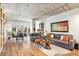 Open-concept living area with a concrete ceiling, wood floors and space for dining at 275 S Harrison St # 210, Denver, CO 80209