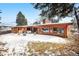 Back exterior view of a single-story home featuring a patio, backyard, mature trees, and snow covered ground at 1333 Mariposa Ave, Boulder, CO 80302