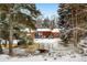 Spacious backyard of the home has a gazebo, patio, mature trees, and a quaint footbridge covered in snow at 1333 Mariposa Ave, Boulder, CO 80302