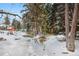 Home's idyllic backyard showcases a decorative bridge, wooden gazebo, mature trees, and a swing-set in a wintery scene at 1333 Mariposa Ave, Boulder, CO 80302