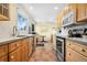 Galley kitchen featuring stainless steel appliances, tile floor, and large window overlooking outdoor greenery at 1333 Mariposa Ave, Boulder, CO 80302