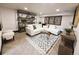 Beautiful basement living room with a sleek white sofa, stylish rug, and attractive shelving unit at 2824 Cherry St, Denver, CO 80207